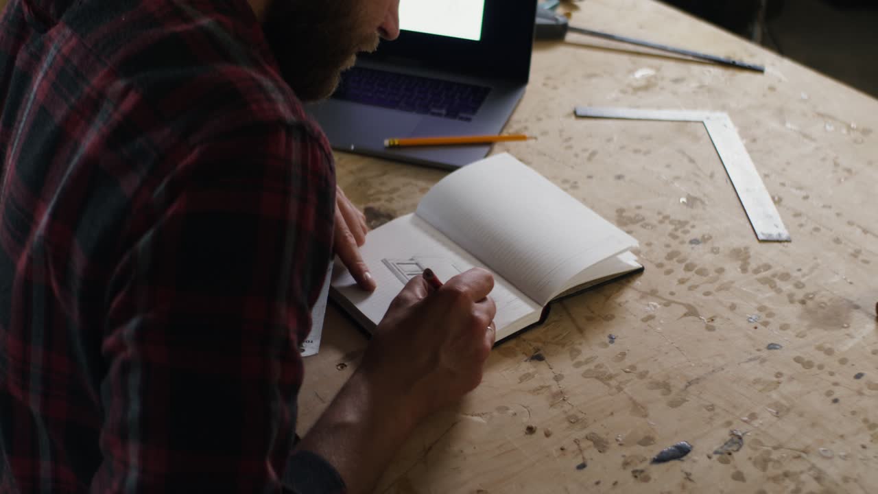 Man Drawing in a Workshop