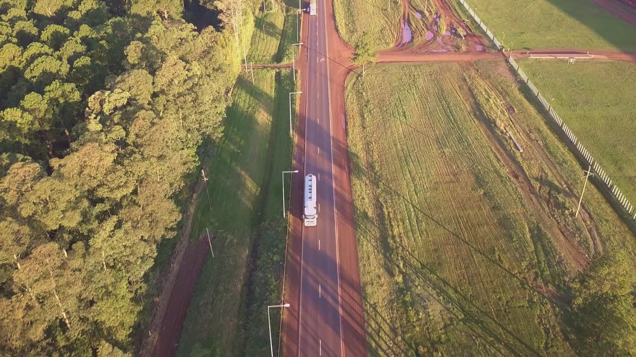 Following a white tank truck on a countryside road. Forestry on one side. Air view cinematic. Drone aerial footage. Part 1