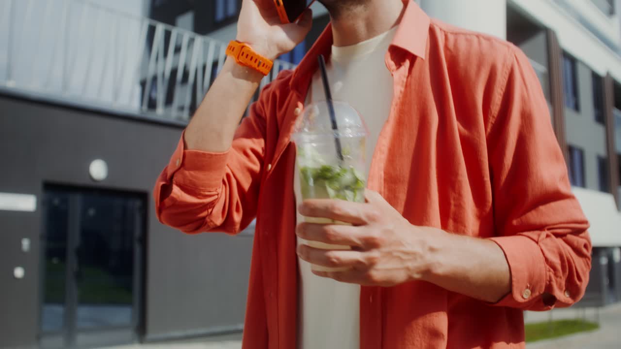 hombre hablando por teléfono y bebiendo un cóctel
