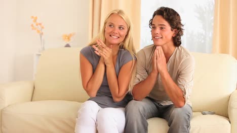excited couple sitting on a sofa