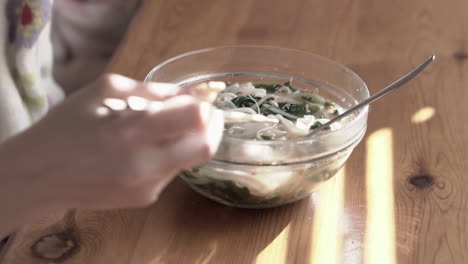 cierre el video agarrando y comiendo albóndigas de una sopa asiática muy caliente usando palillos