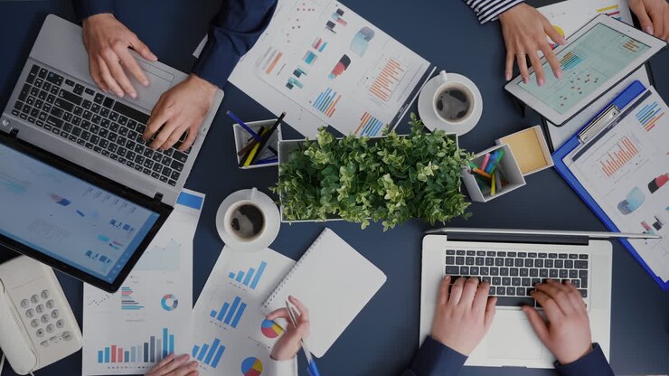 Draufsicht von Unternehmern, die Unternehmensdiagramme analysieren, Dokumente zur Entwicklung einer Finanzstrategie