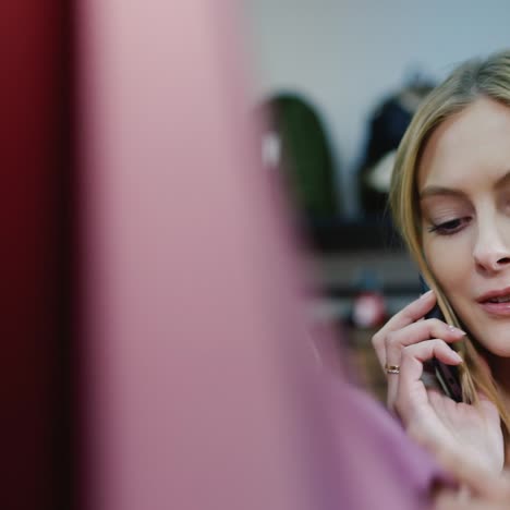 young caucasian woman speaks on the phone in a clothing store