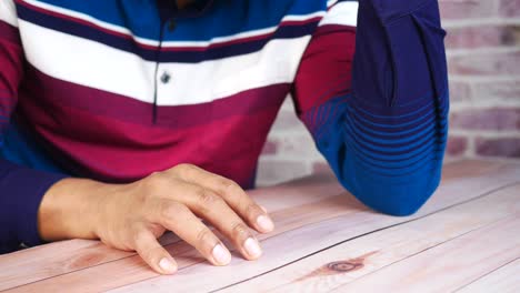 hombre sentado en una mesa con una camisa a rayas