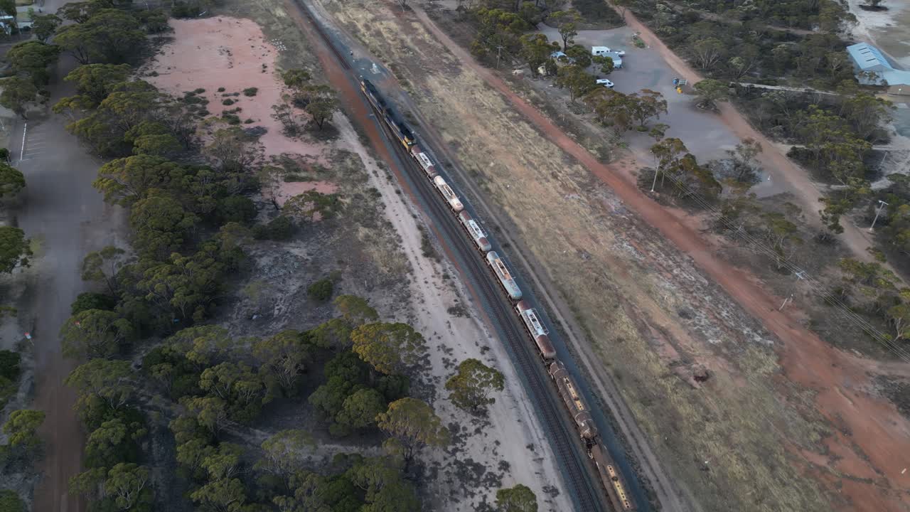 Treno merci in movimento che trasporta carburante nella zona di Esperance, Australia Occidentale, ripresa aerea in movimento.