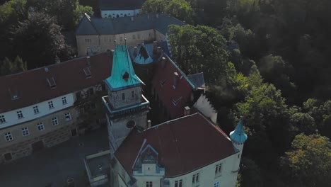 chateau hruba skala in bohemian paradise, czech republic, trosky castle in the distance, drone view - orbiting, pan up and fly down, 4k or uhd, 30fps