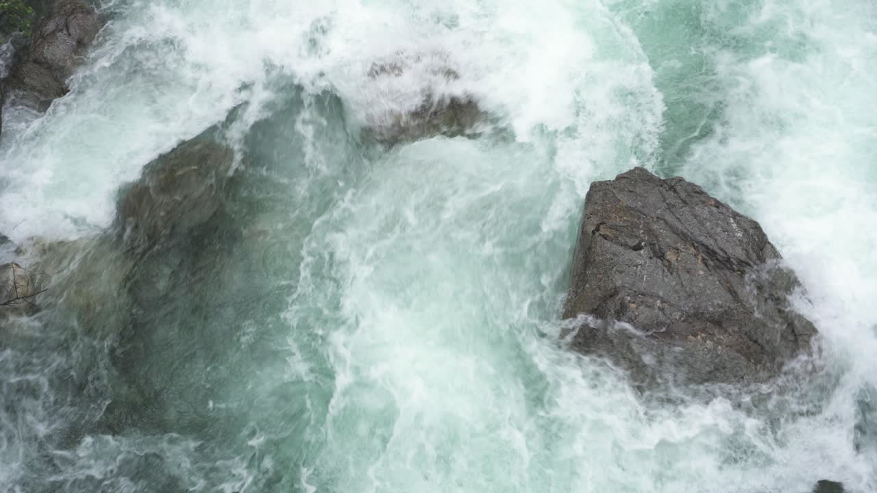 산허리 바위 위로 흐르는 빙하 용융 급류, 공중 하향식 전망