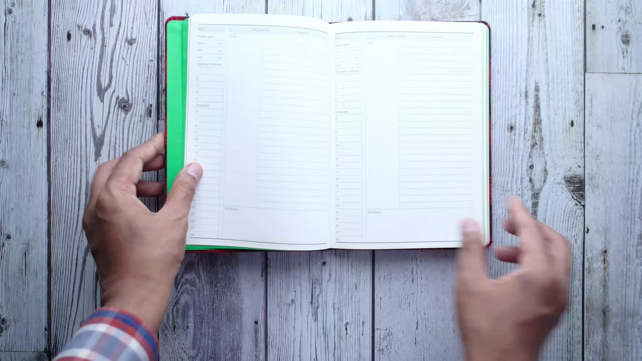 Person Opening a Blank Notepad on a Wooden Table