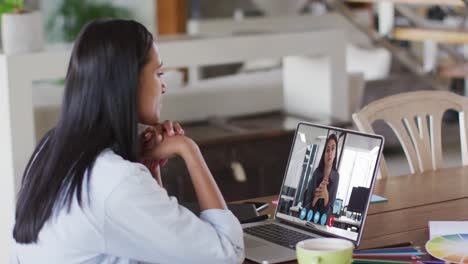 african american woman having a video call with female colleague on laptop at home