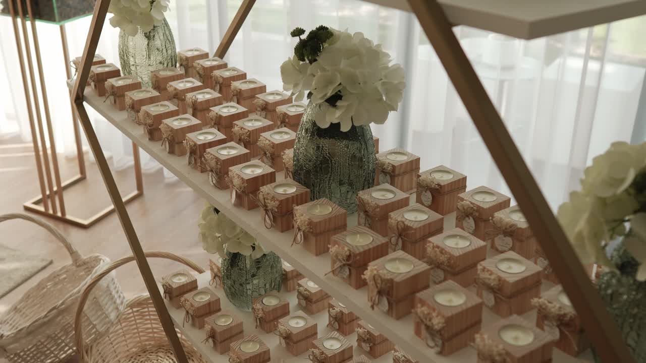 rustic wedding favors in small wooden boxes with candles and lace arranged on elegant shelves