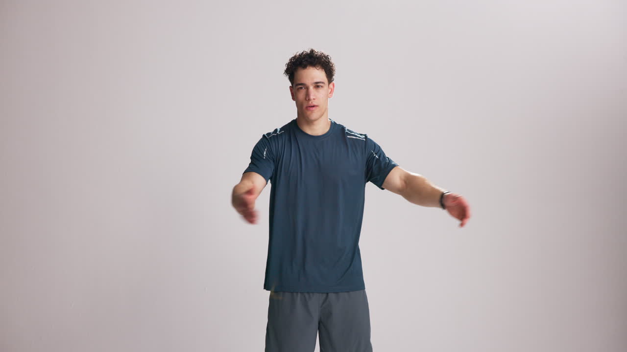 Young Man Stretching Arms and Torso in Studio
