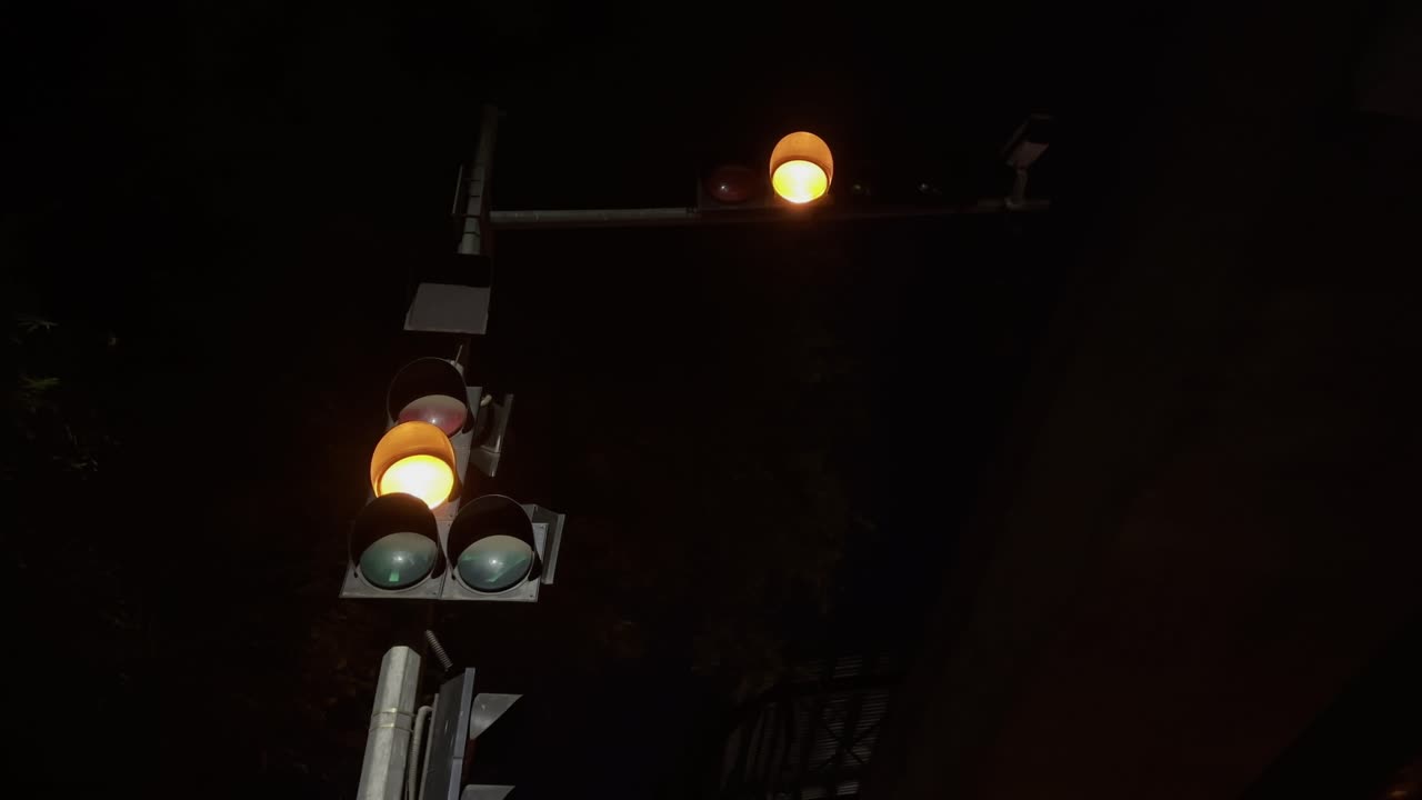 A pulsating orange light in the night, particularly one at an intersection, usually indicates a cautionary signal, meaning drivers should proceed with care.
