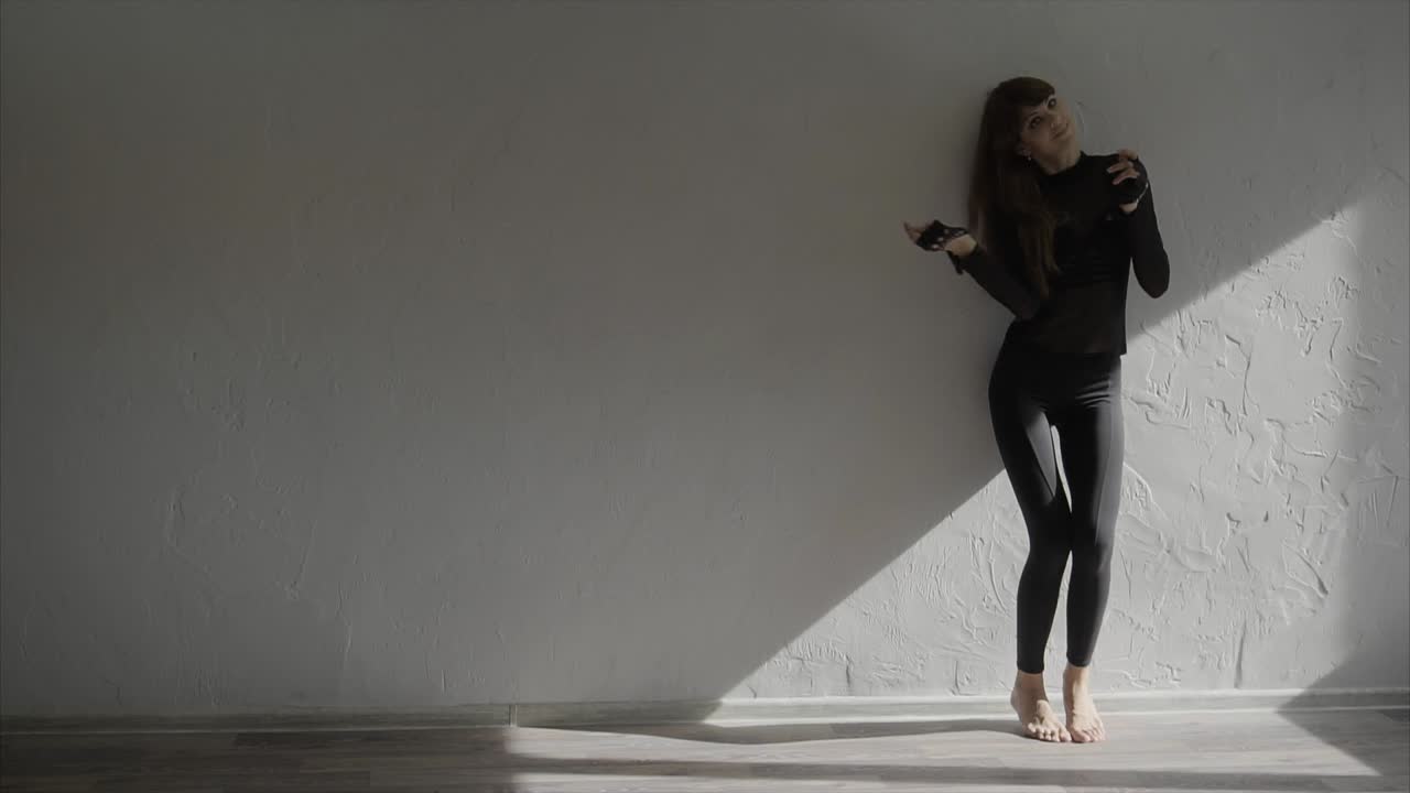Woman in Black Outfit Posing Against a Wall