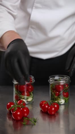 chef preparing preserved cherry tomatoes in jars