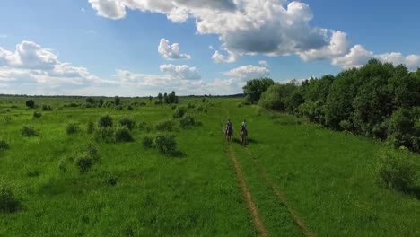 personas a caballo en un campo verde