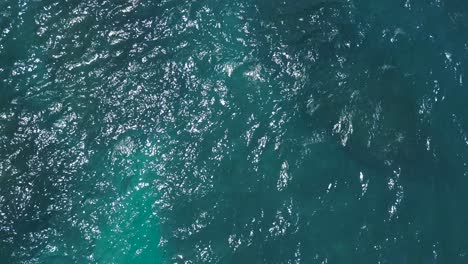 Aerial-view-of-the-waves-of-crystal-blue-water-on-shore-line-of-diamond-beach-in-Nusa-Penida,-Indonesia