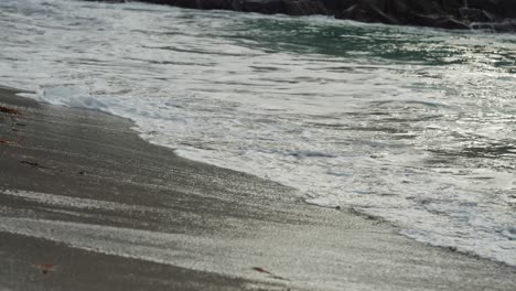 A-close-up-shot-of-the-long-tidal-waves-spilling-on-the-sandy-shore