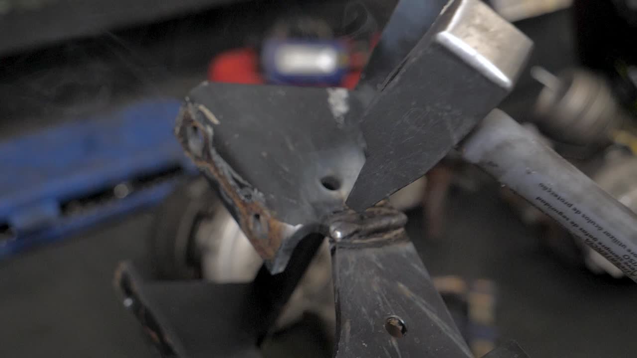 Knocking with a hammer in slow motion in a mechanic garage