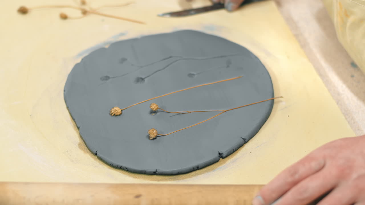 The master of sculpting pottery working in a studio. Taking of compressed twigs from the clay