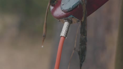 close-up of a red hose attached to a metal outdoor device