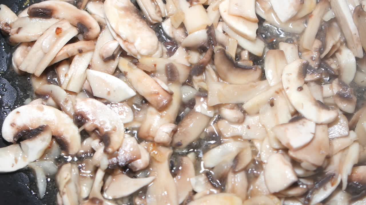 Frying sliced mushrooms in a pan