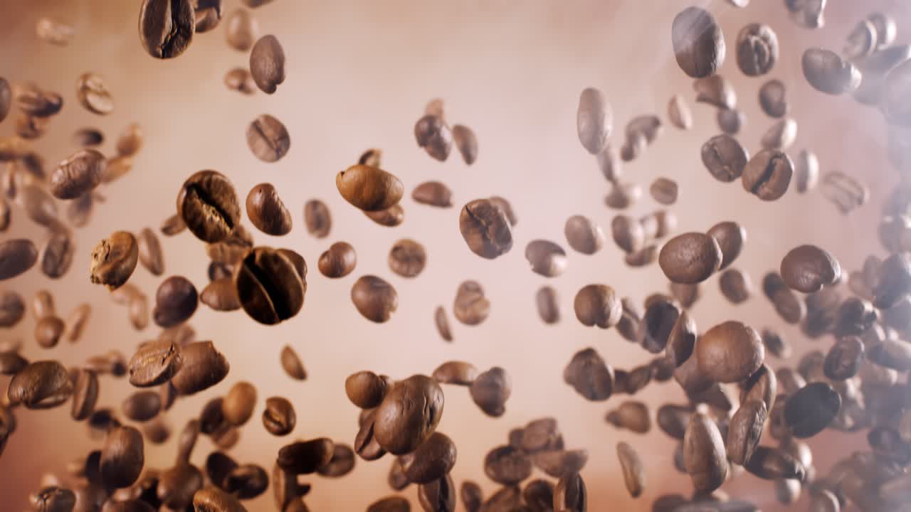 Fragranza di chicchi di caffè che fluttuano nell'inquadratura. Chicchi di caffè ripresi con una fotocamera super slow motion a 1000 fps.