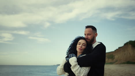 gente romántica abrazándose en la playa, una pareja tranquila mostrando amor en la naturaleza.