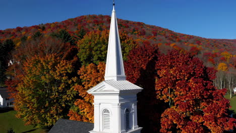 white church steeple amidst vibrant autumn foliage