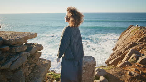carefree brunette resting seashore landscape back view. woman looking camera