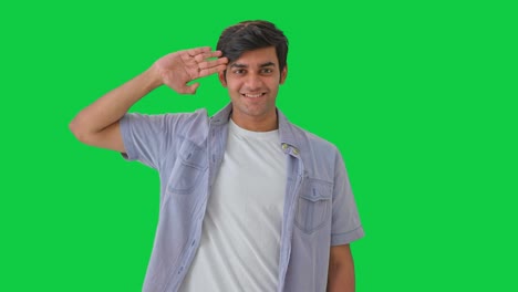 proud young indian boy saluting green screen