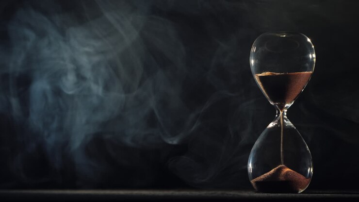 sanduhr auf schwarzem hintergrund mit wirbelndem nebel