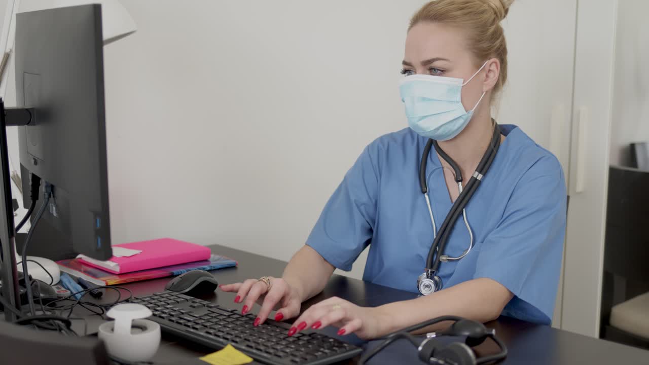 médico con máscara usando una computadora