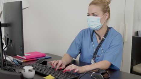 Medical-practitioner-in-mask-using-computer