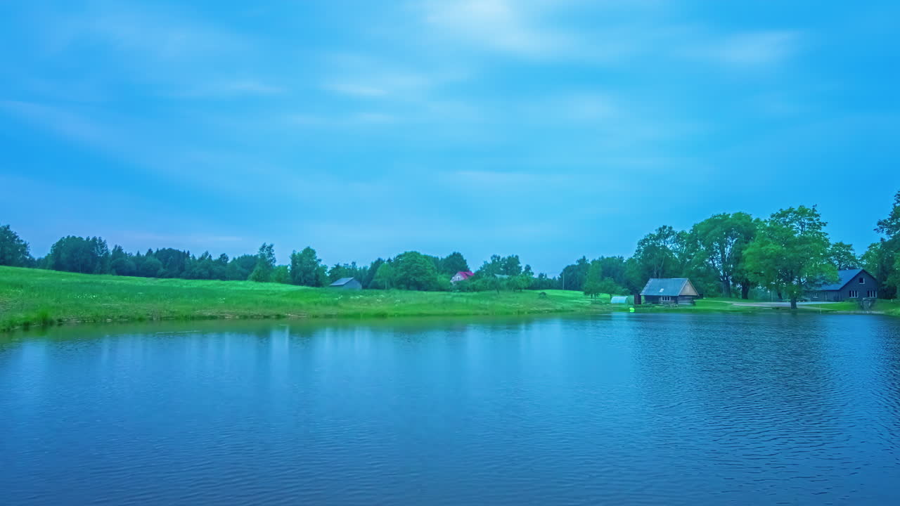 라트비아의 호수와 시골 농지의 타임 스 (time-lapse of a lake and countryside farmland in latvia with a radiance of blue twilight)
