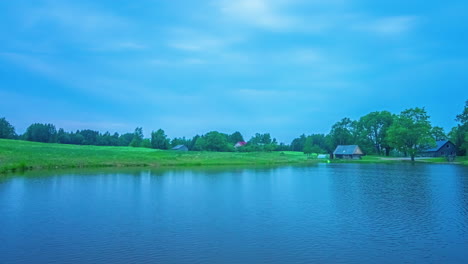 timelapse of a lake and countryside farmland in latvia with a radiance of blue twilight