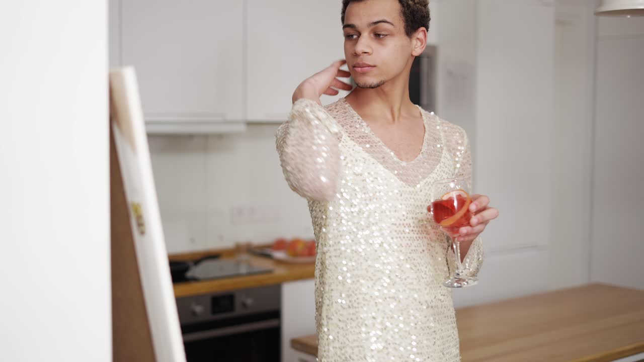 Il ragazzo vestito con un abito bianco si pettina i capelli, guardandosi allo specchio.