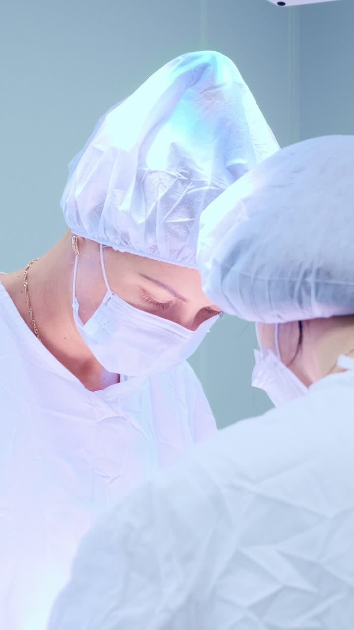Medical professionals in surgical attire collaborating in a bright operating room environment