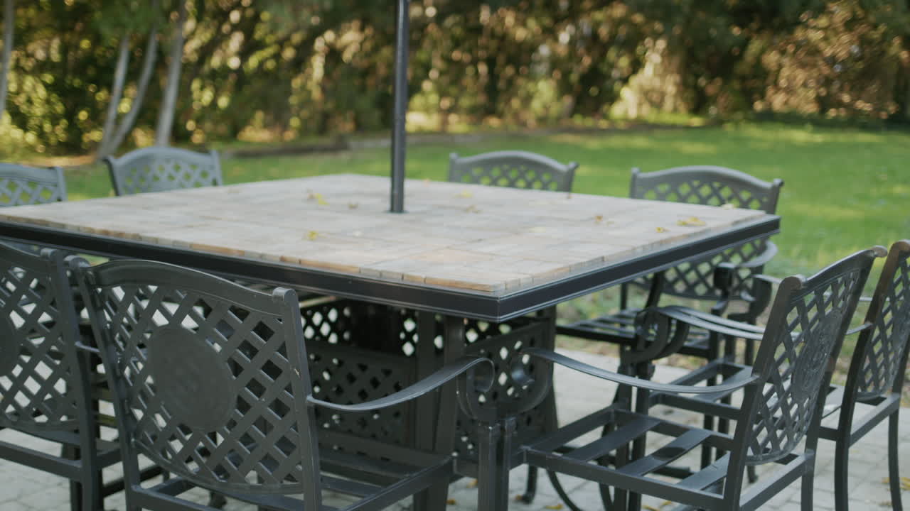 Empty tables with chairs pulled up - summer terrace of the cafe without visitors