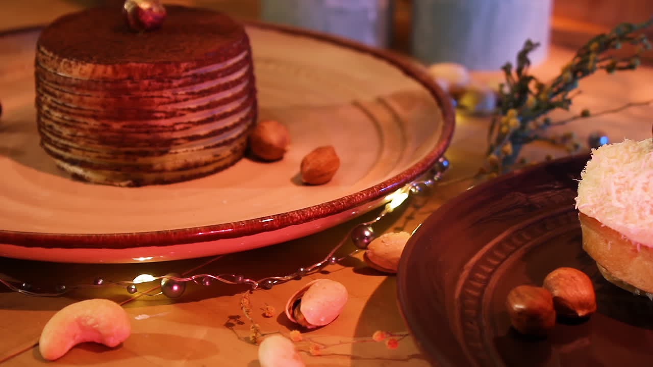 delicioso pastel de chocolate y eclair de coco en platos con nueces esparcidas sobre la mesa