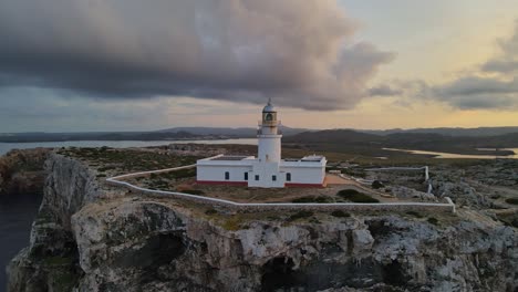 drone flight around lighthouse in spain with dark black clouds in the distance