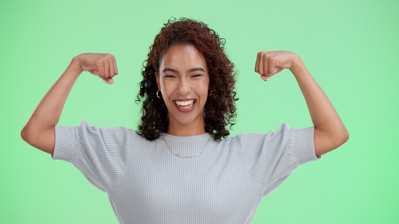 Confident woman flexing her muscles with a big smile
