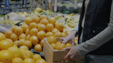 woman buying oranges in a grocery store