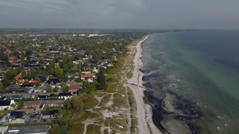 widok z drona na duńskie wybrzeże z domkami letniskowymi w pobliżu plaży