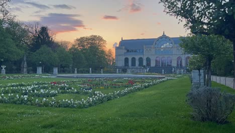 Zeitraffer-Eines-Parks-Mit-Vielen-Blumen-Mit-Einem-Schönen-Haus-Am-Abend-In-Köln