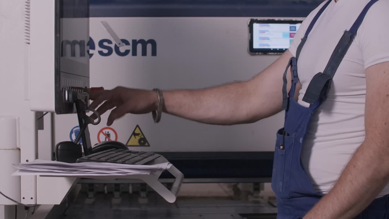 Industrial worker operating a machine control panel