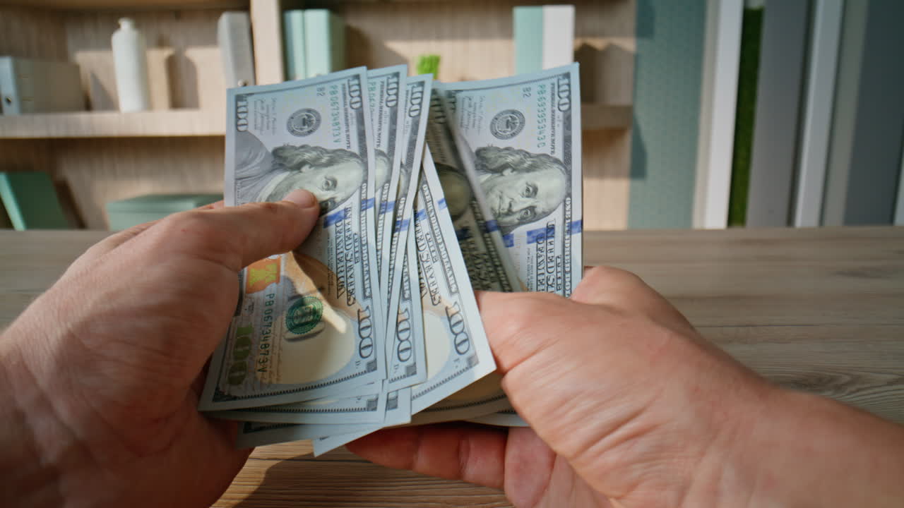 Successful businessman calculating dollars cash at office workplace closeup