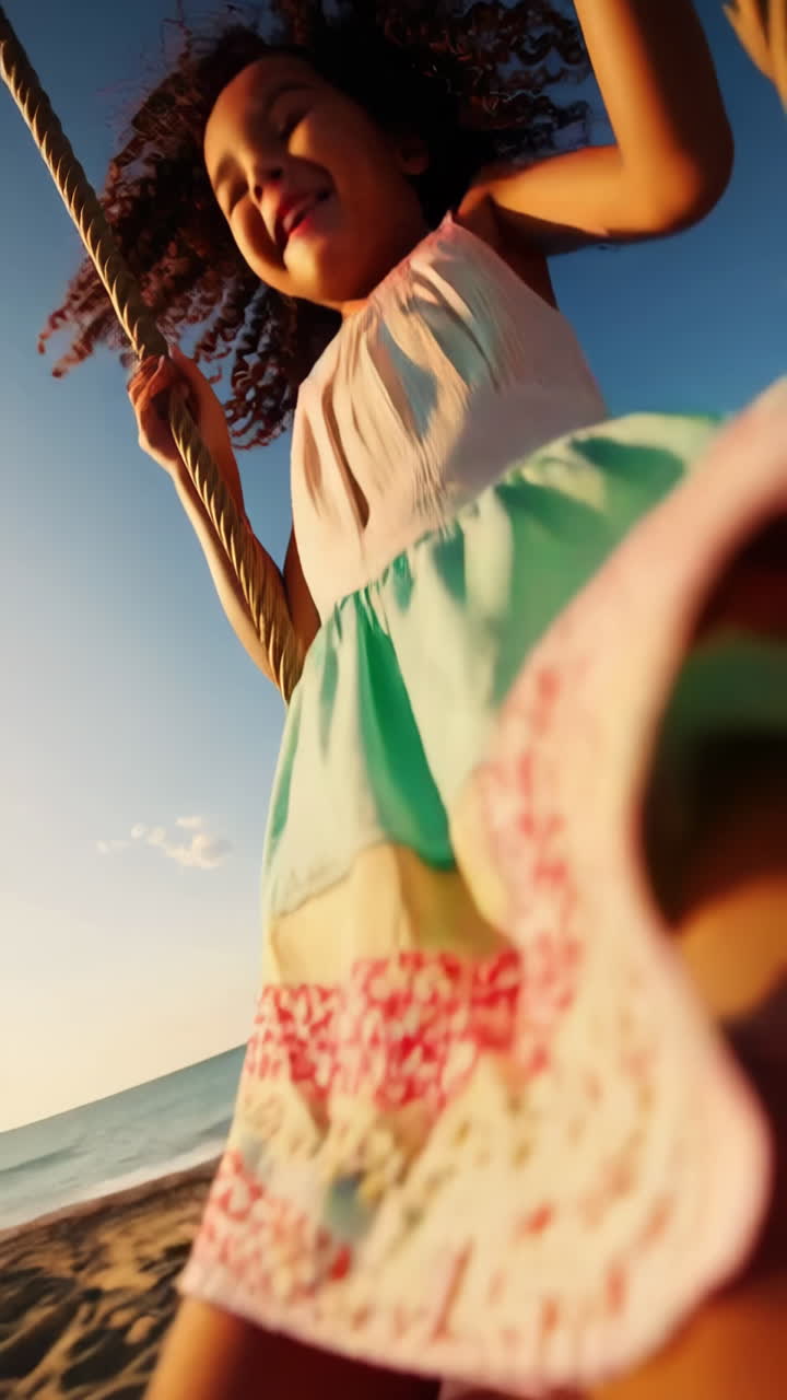 Joyful girl swinging on a beach swing