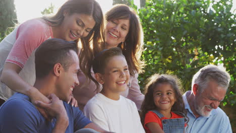 Multi-Generation-Hispanic-Family-Relaxing-In-Garden-At-Home-Together