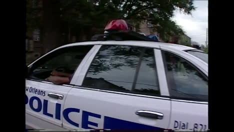 1980s grainy news footage of police patrolling run down neighborhoods in new orleans louisiana