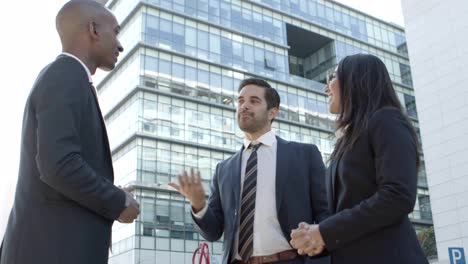 Cheerful-business-colleagues-meeting-on-street